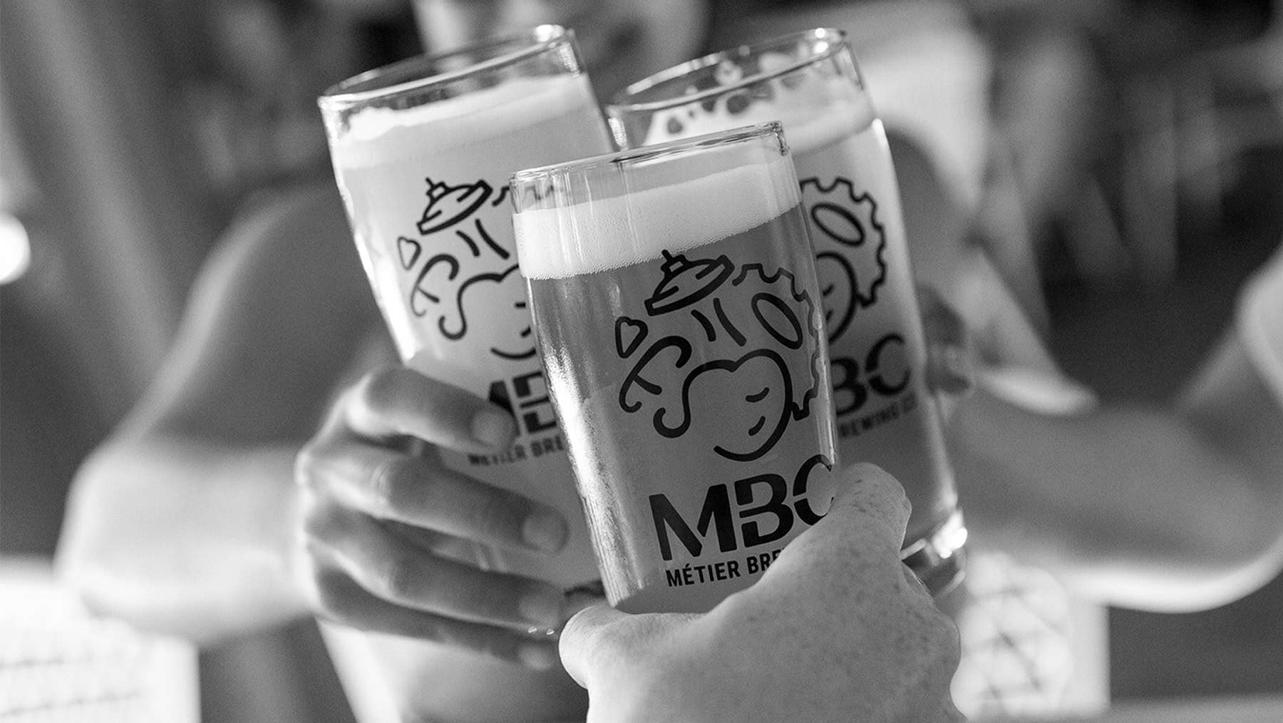 A black and white photo of three full glasses of beer