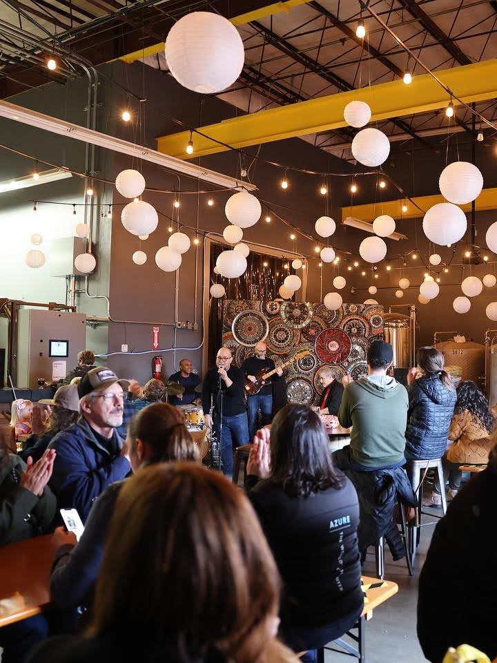 A live band playing for a full bar of customers.