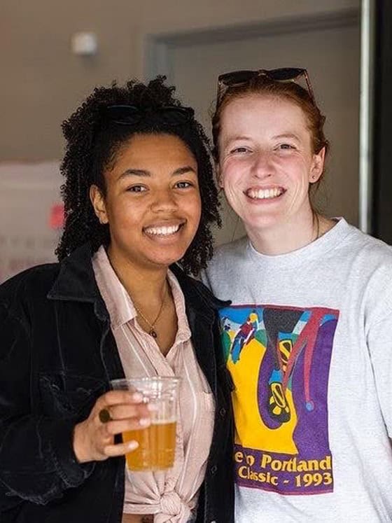 Two people smiling side by side at the camera.