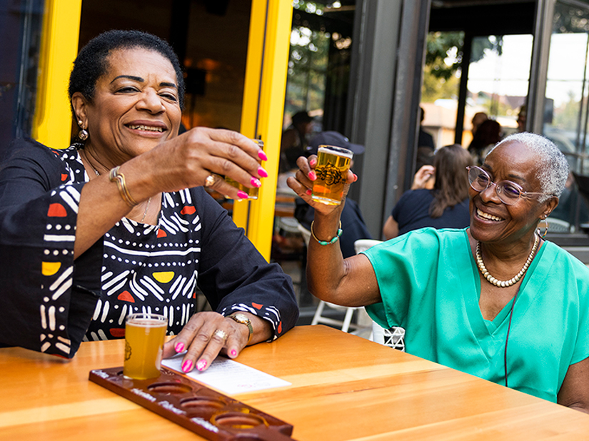 Two people holding their full shot glasses up.