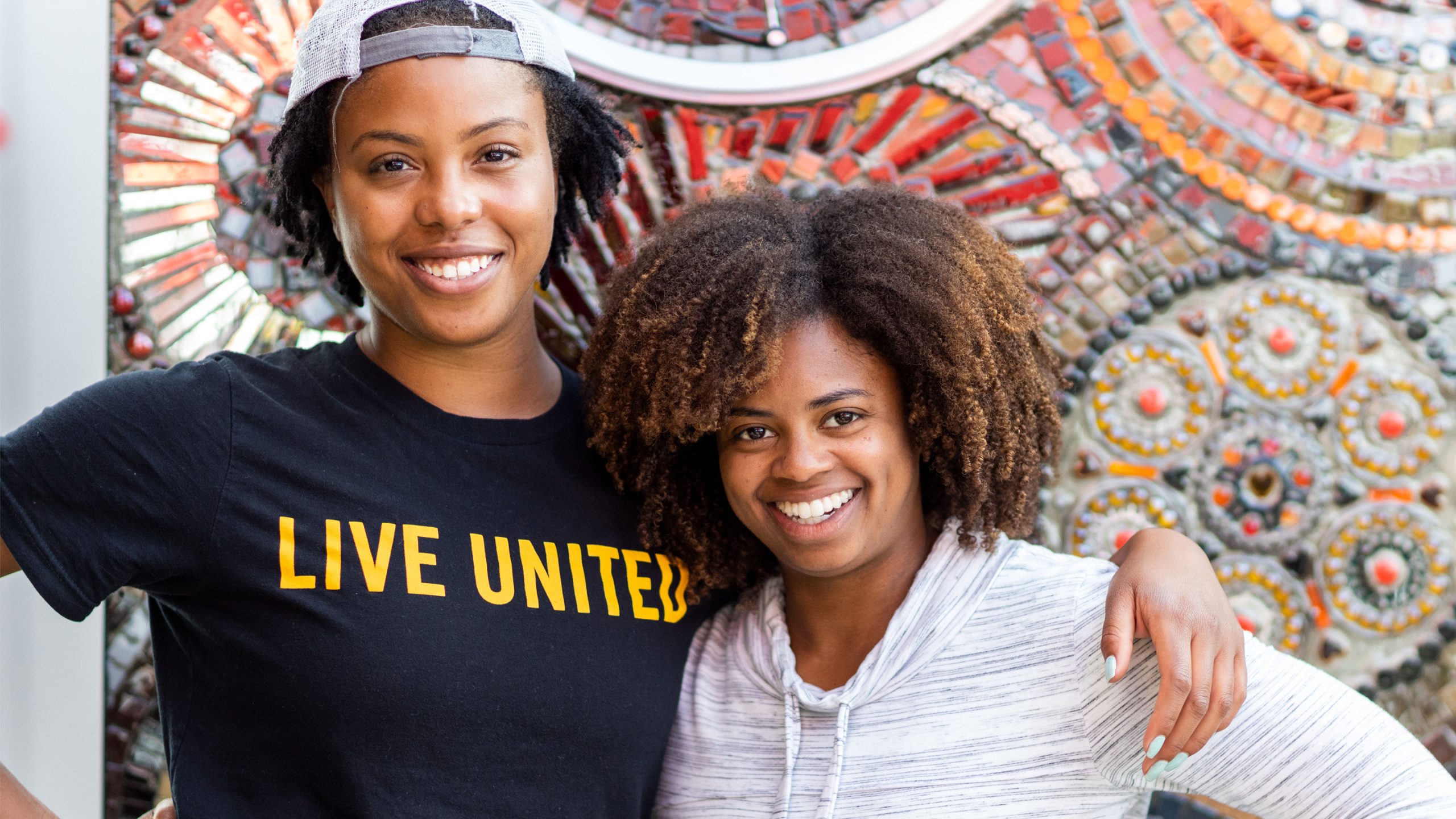 Two people smiling side by side at the camera.