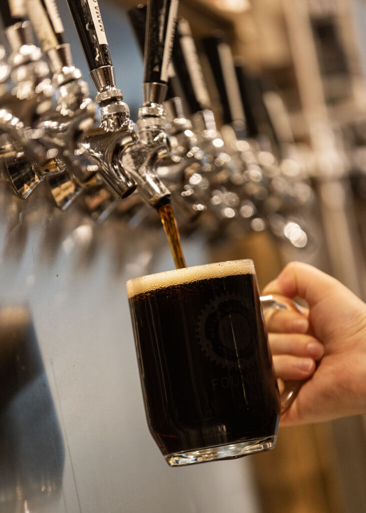 A mug of MBC root beer being poured at the tap